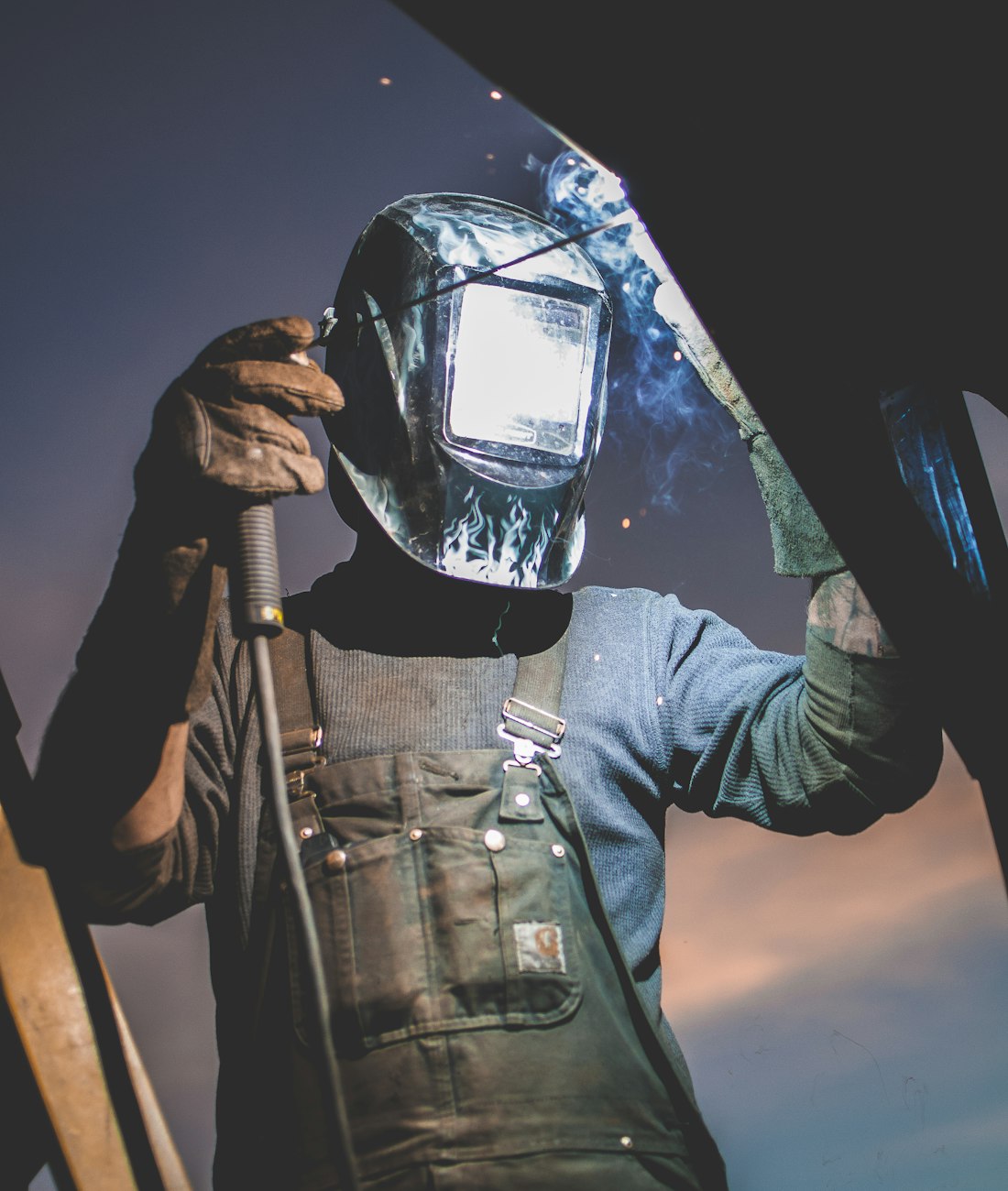 Welder in helmet, focused on a weld