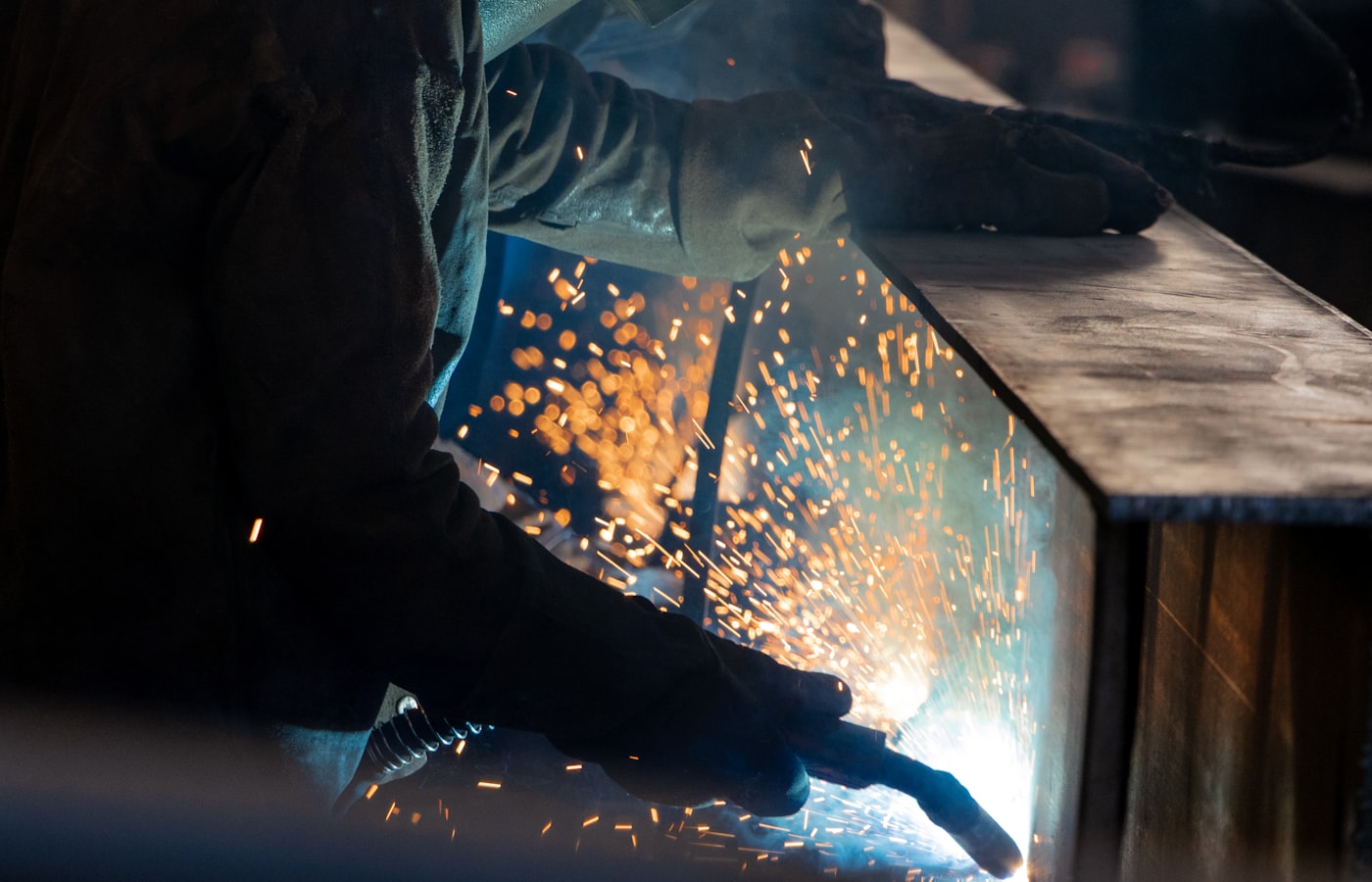 Welder running a bead in a workshop with sparks flying