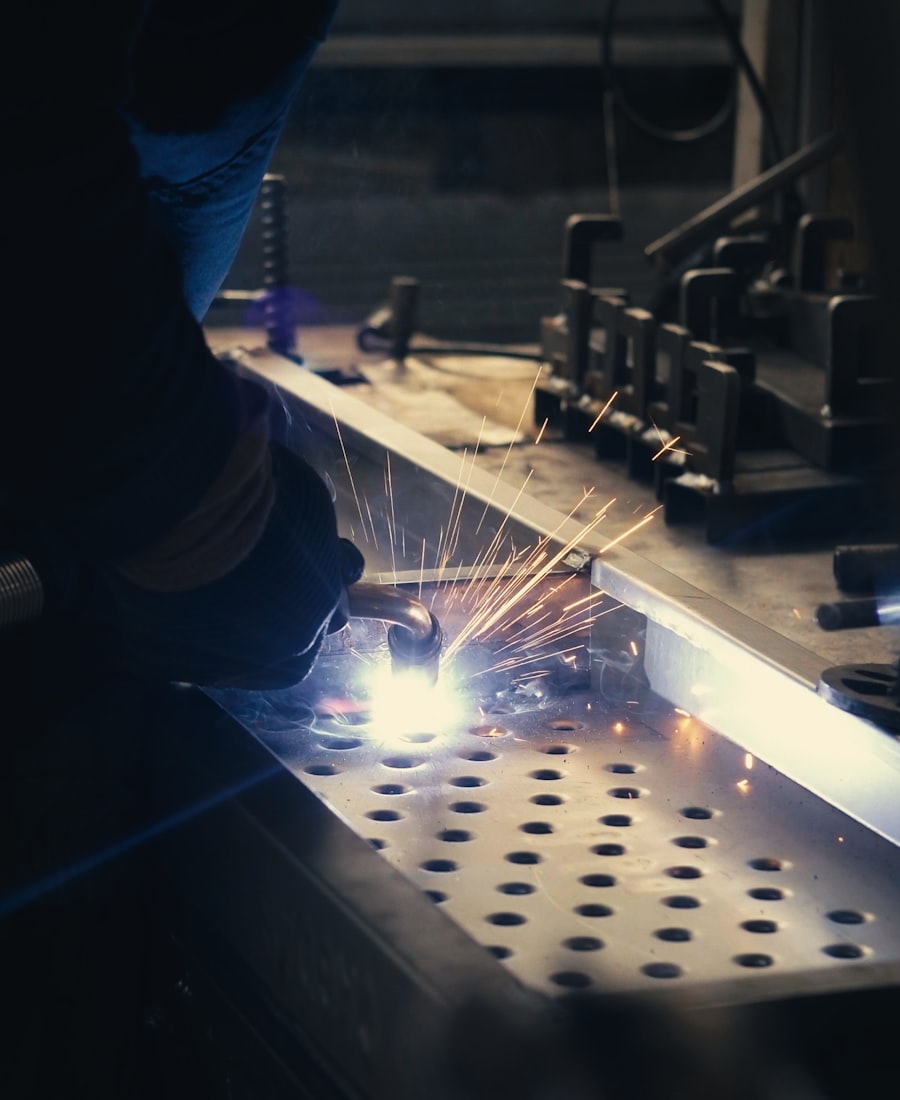 Welder bonding metal close-up with goggles and visible sparks