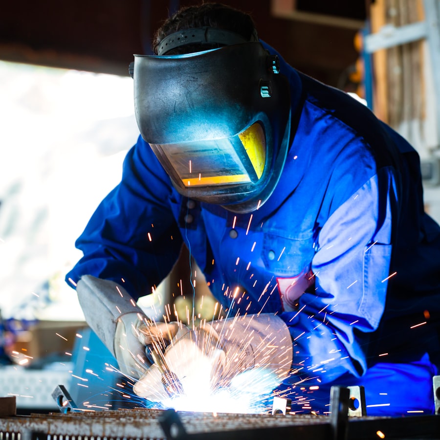 Welder working in a dark room, focused on the arc
